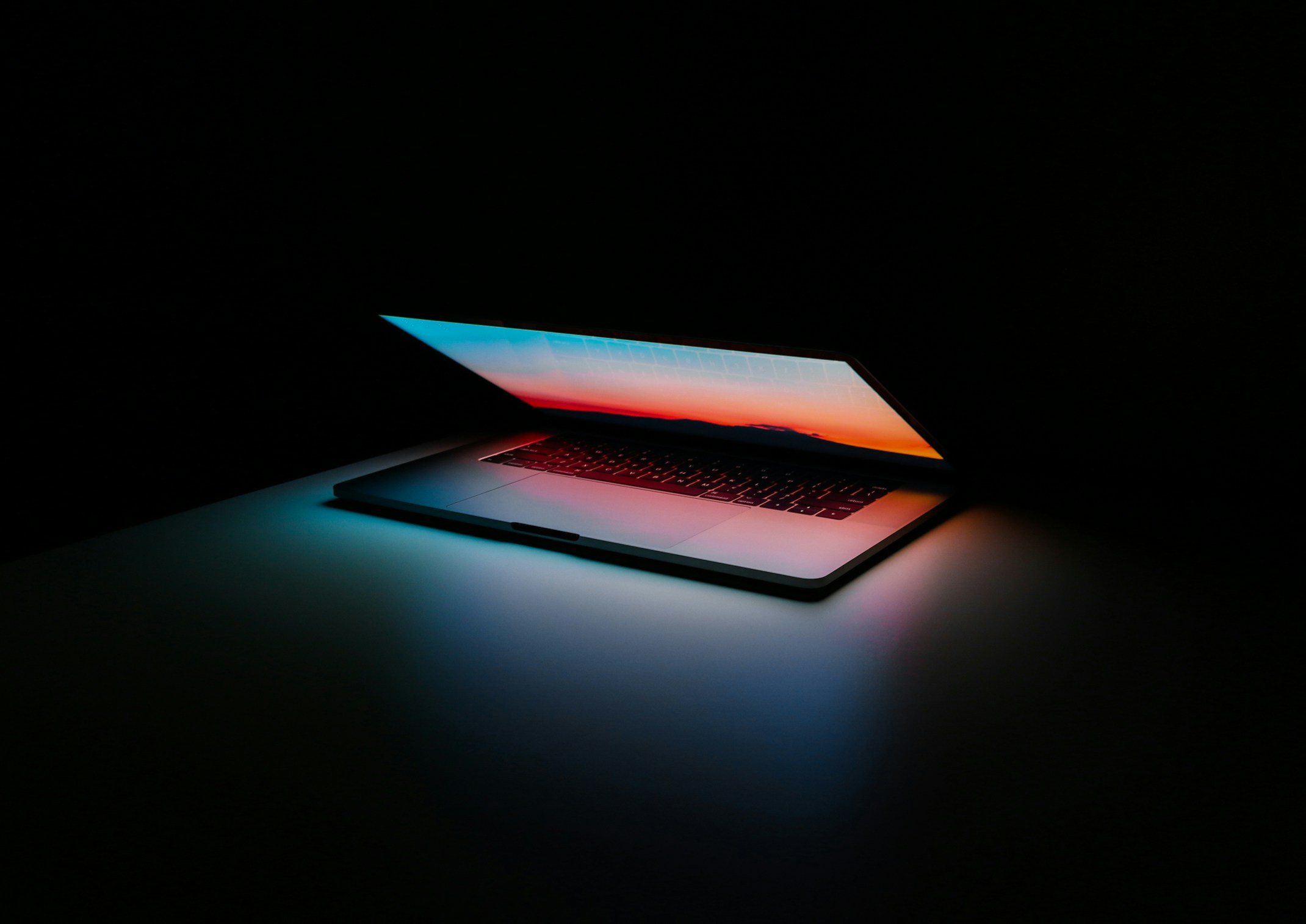 Otwarty laptop podświetlony na ciemnym tle